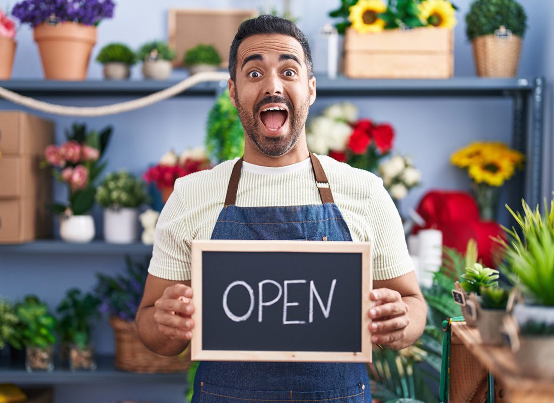 Business Insurance - Excited Flower Shop Owner Holds Up Open Sign